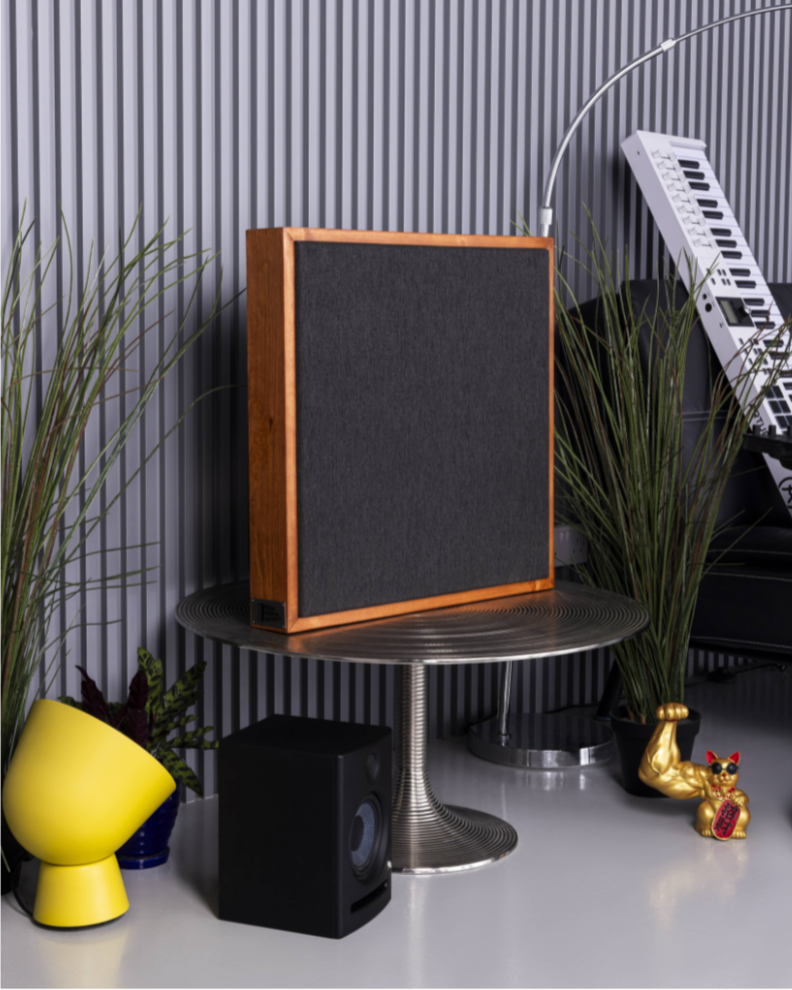 Wooden speaker on a stand with decorative items in a room setting | Room Control Authority