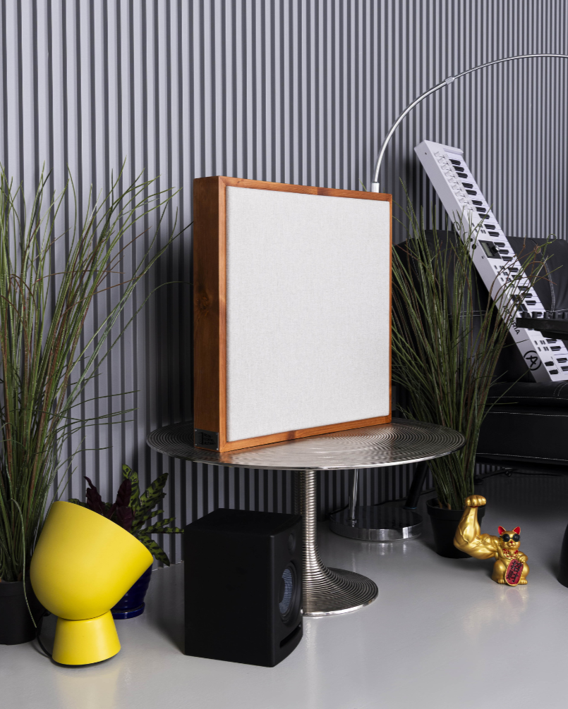 Decorative setup with a speaker, plants, and small objects on a surface against a striped wall | Room Control Authority